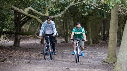 Two people cycling through woodland at Osterley Park and House, Middlesex